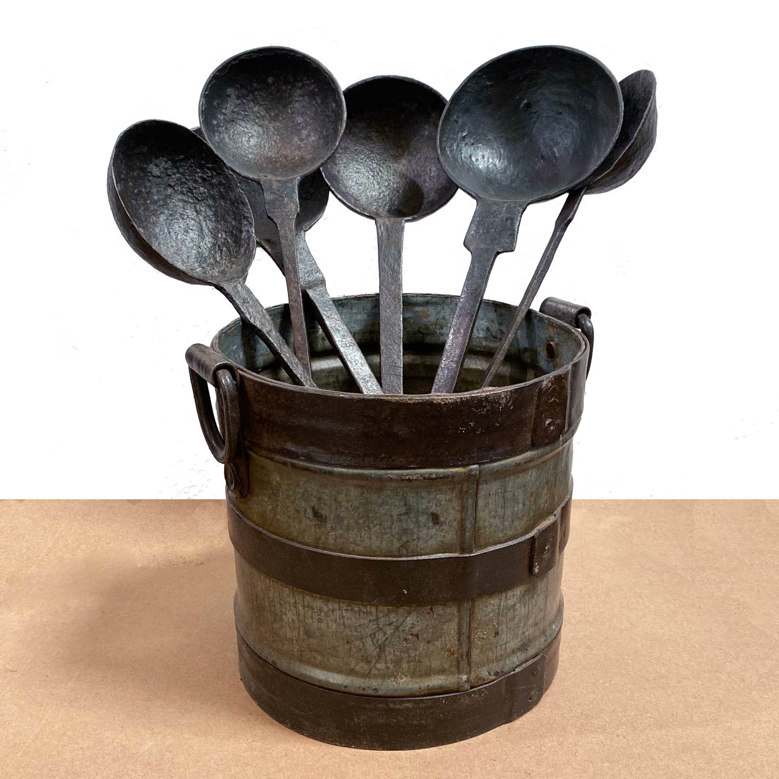 recipiente metálico con antiguos cucharones de hierro