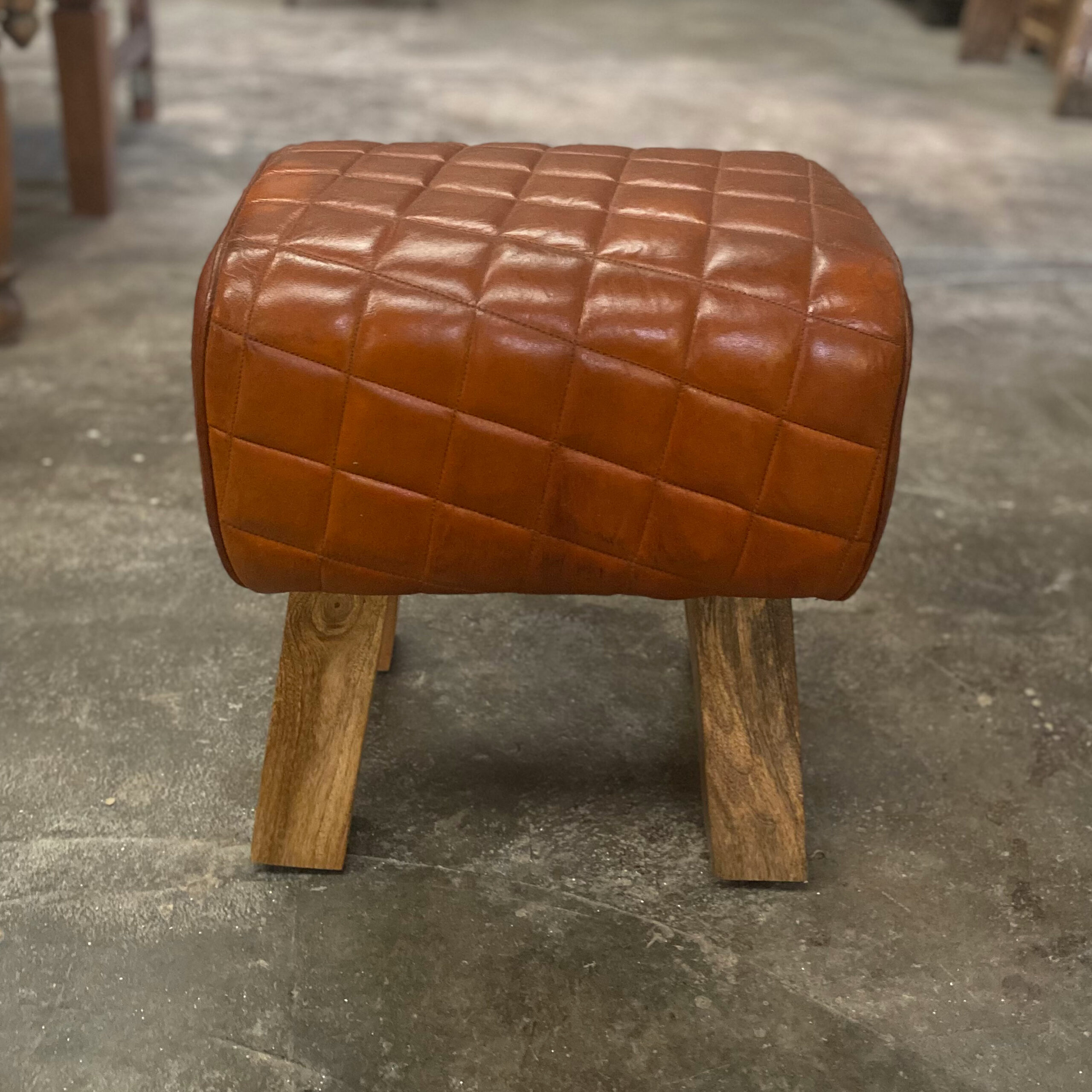 Taburete bajo de piel acolchada