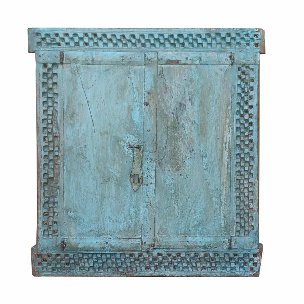 Ventana con porticoles tallados con motivos geométricos en azul